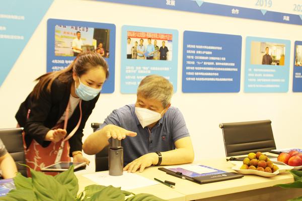 爱国小男孩科技销售人员为刘兆彬会长演示产品
